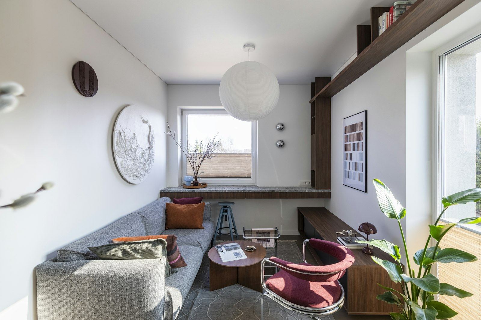 Living del departamento Jarilla, con sillón gris y ventana al frente