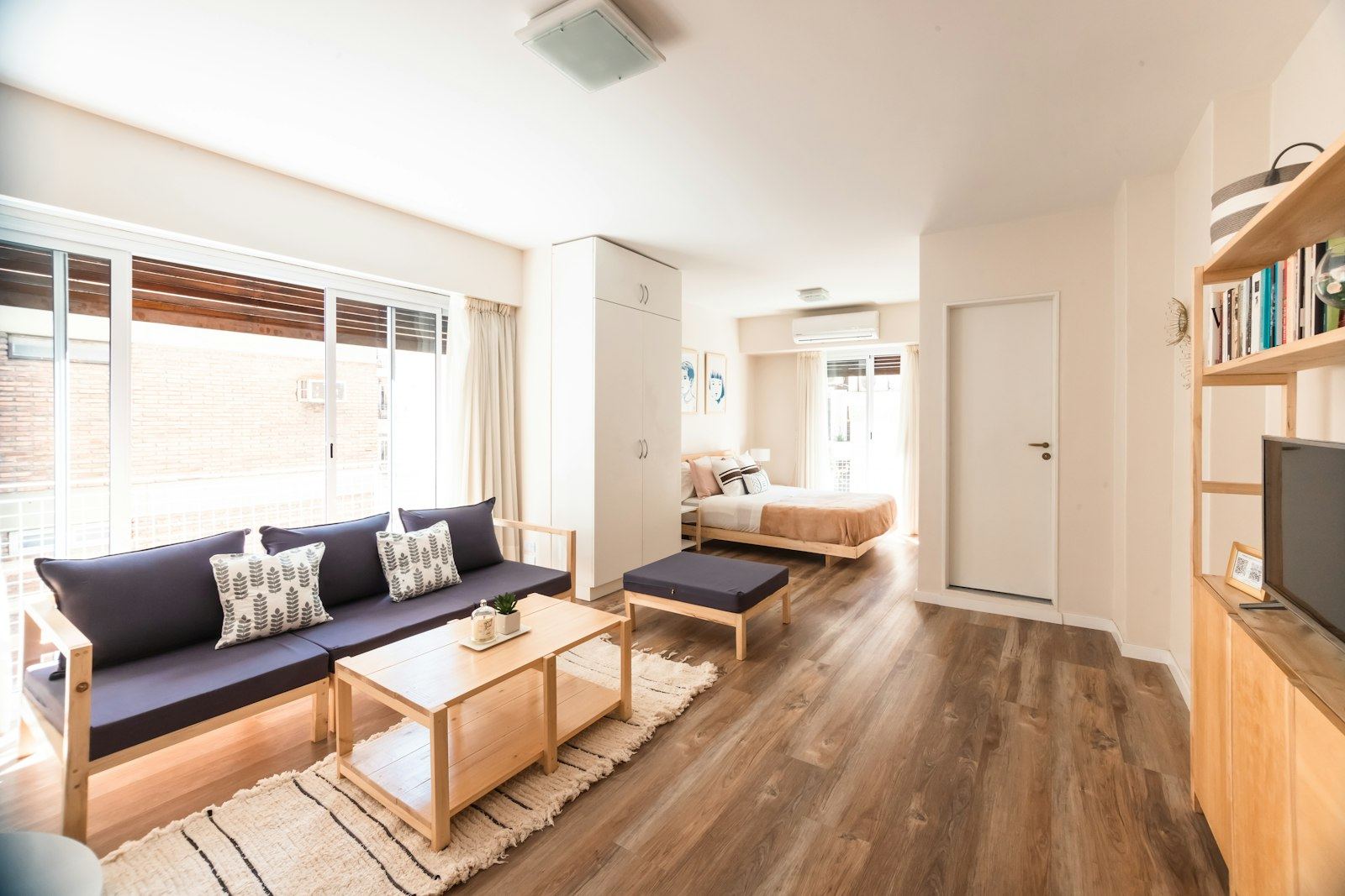 Living amplio del departamento Chacay, con piso de madera